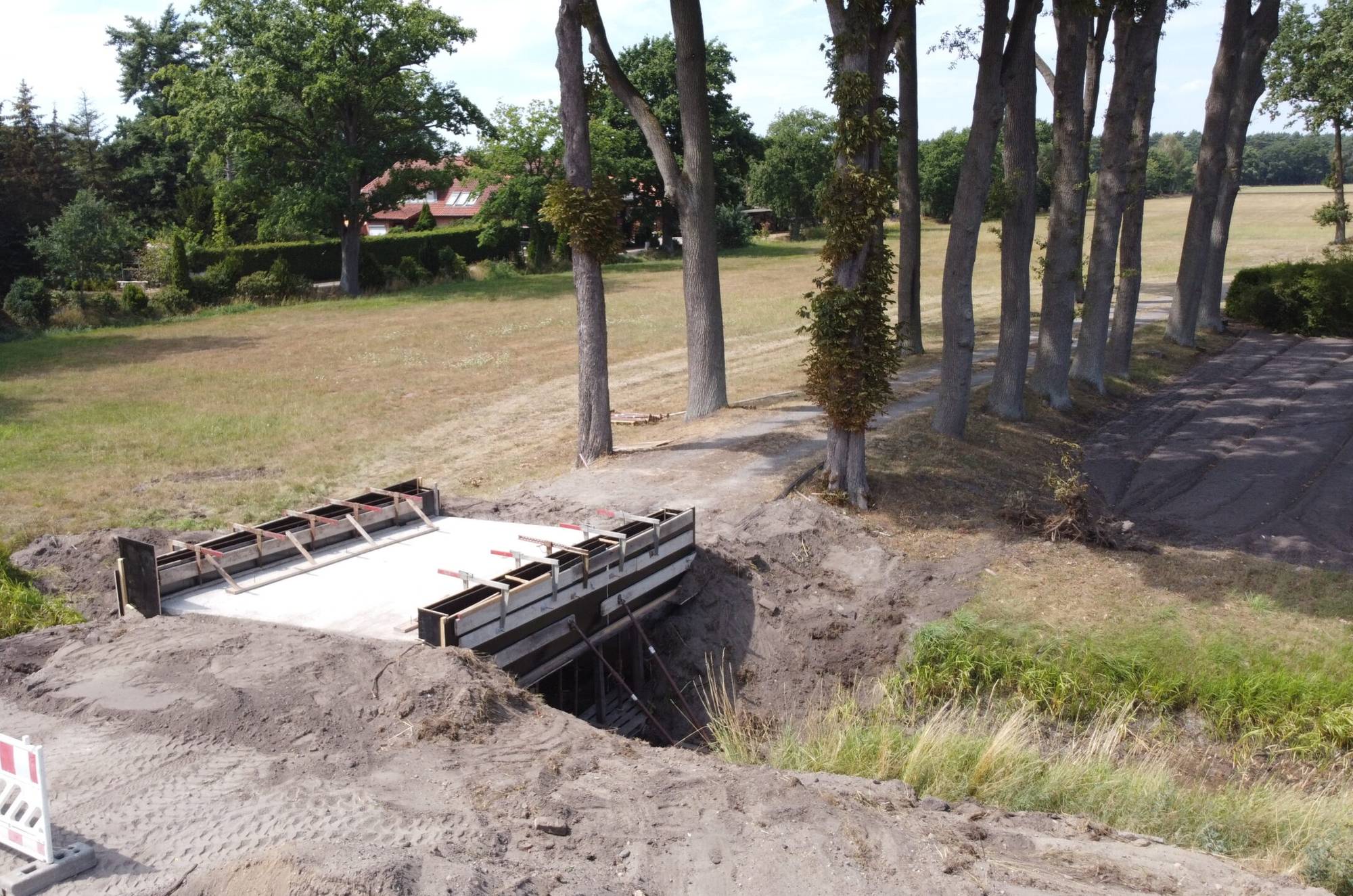 Brückenbau am Graben: betonierte Platte mit Schalung für die Aufkantungen, aus der Luft