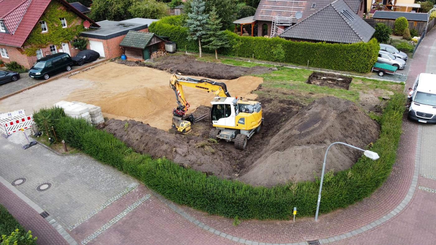 Aushub auf einem Baugrundstück mit Bagger, aus der Luft
